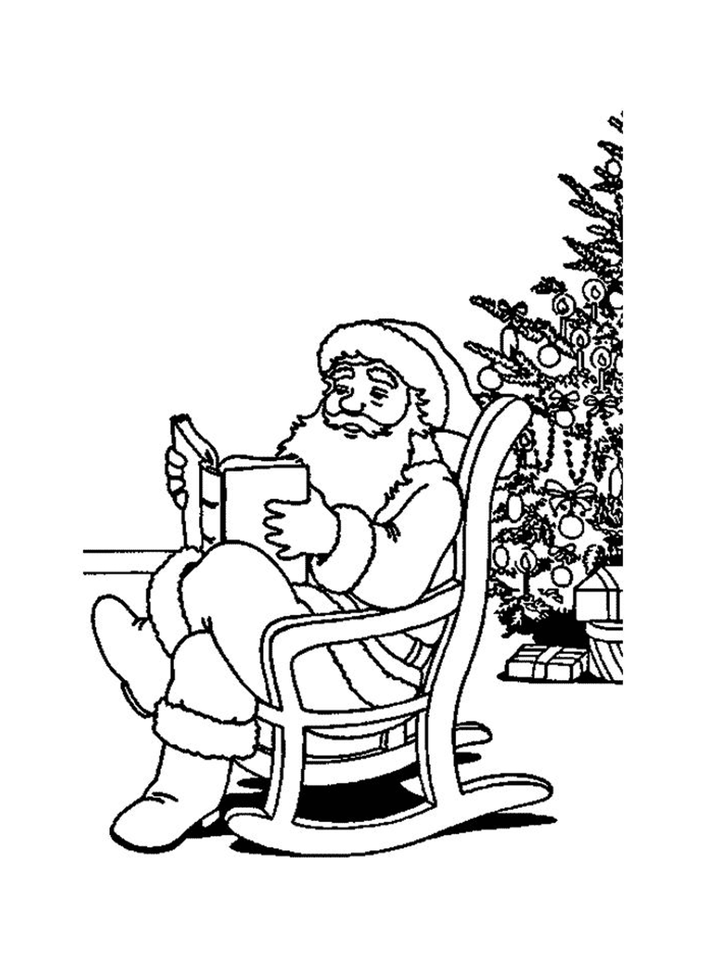   Père Noël lisant un livre près d'un sapin 