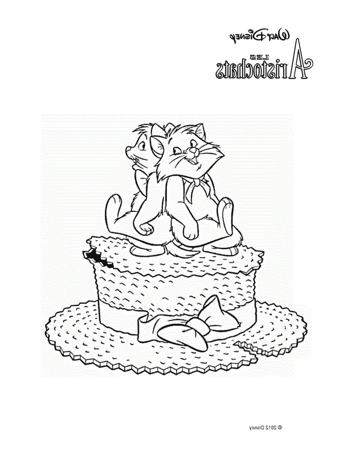   Deux chats assis sur un gros gâteau 