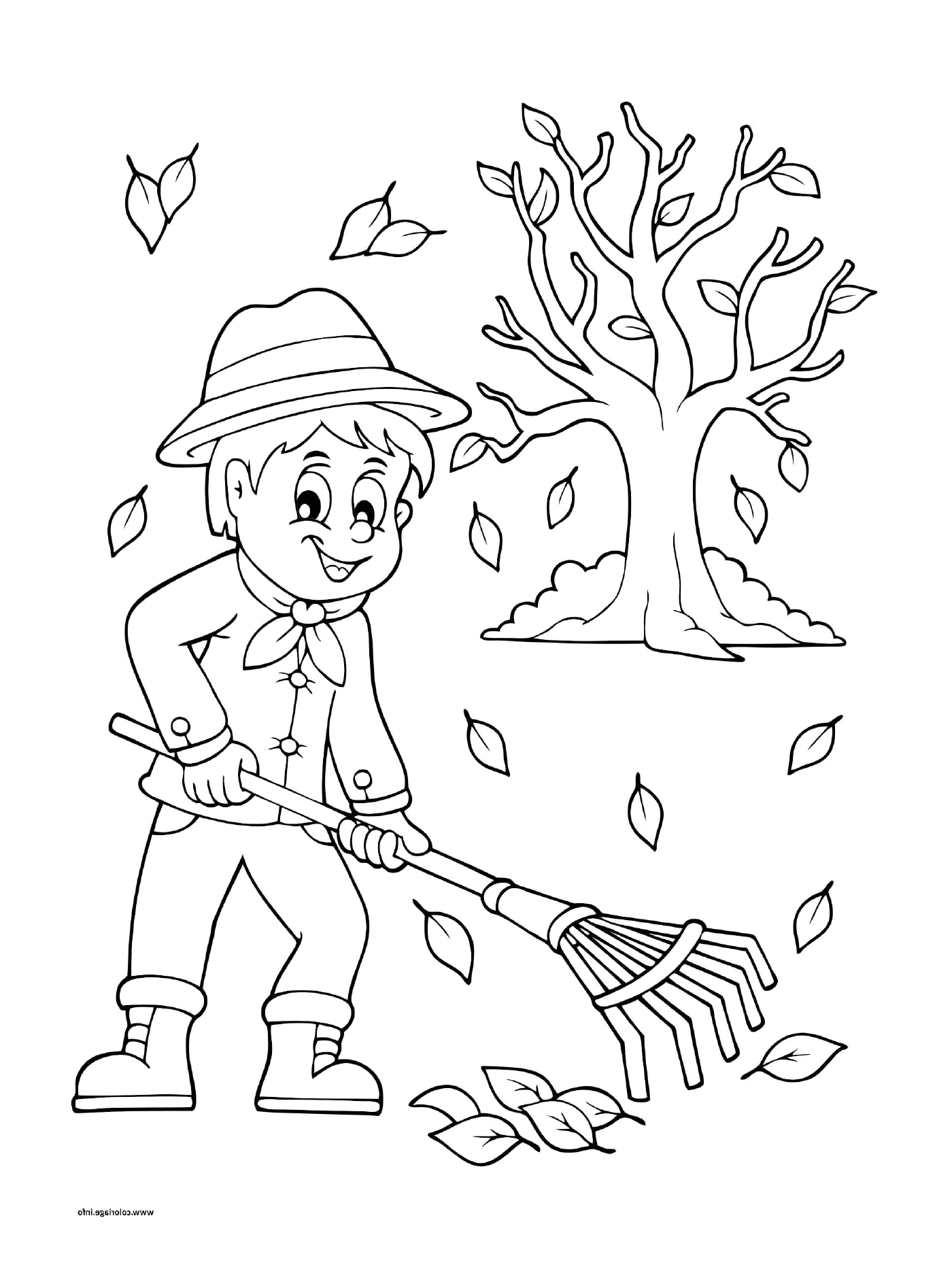   Un garçon qui ratisse les feuilles en automne 