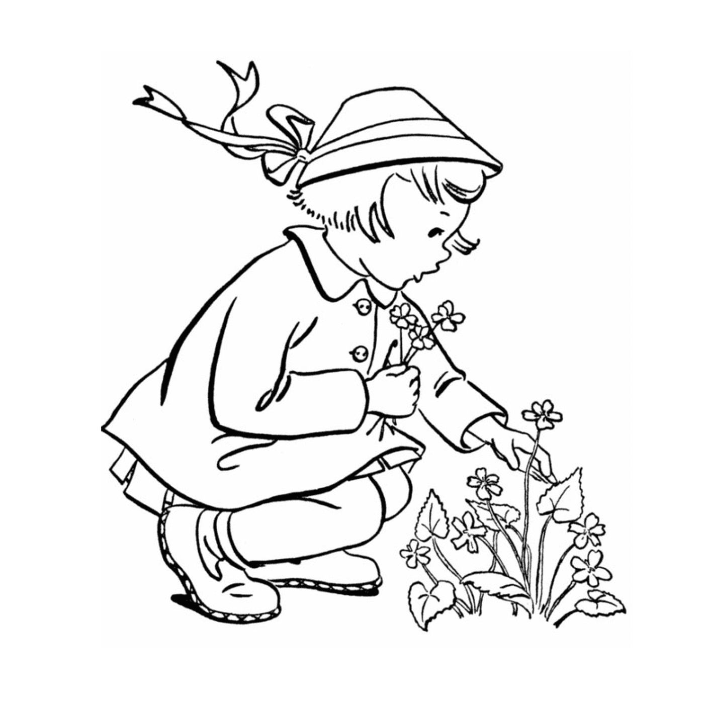   Une petite fille qui s'agenouille pour planter une fleur 
