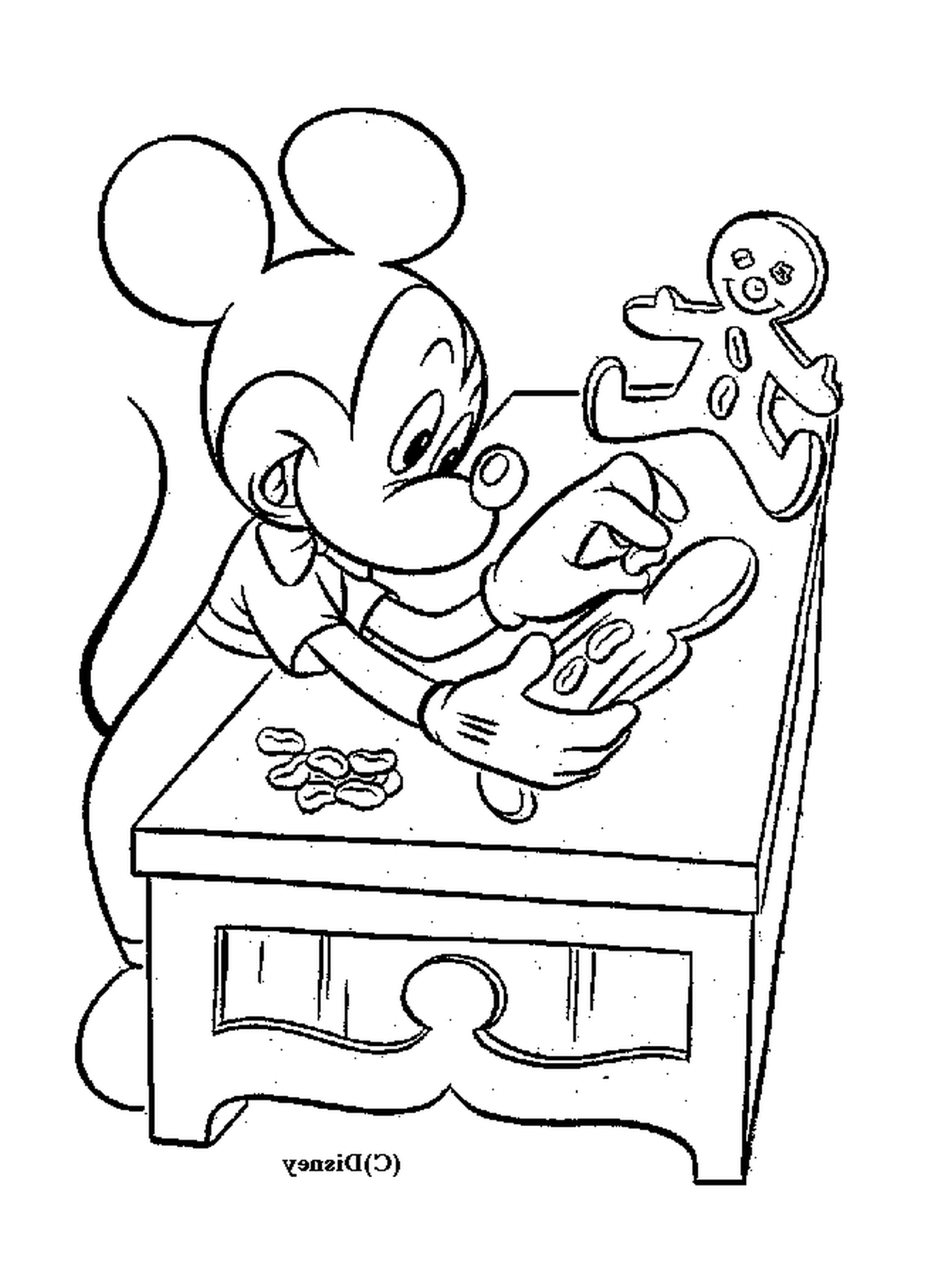   Mickey fait des gâteaux : assis à une table avec un bonhomme en pain d'épice 