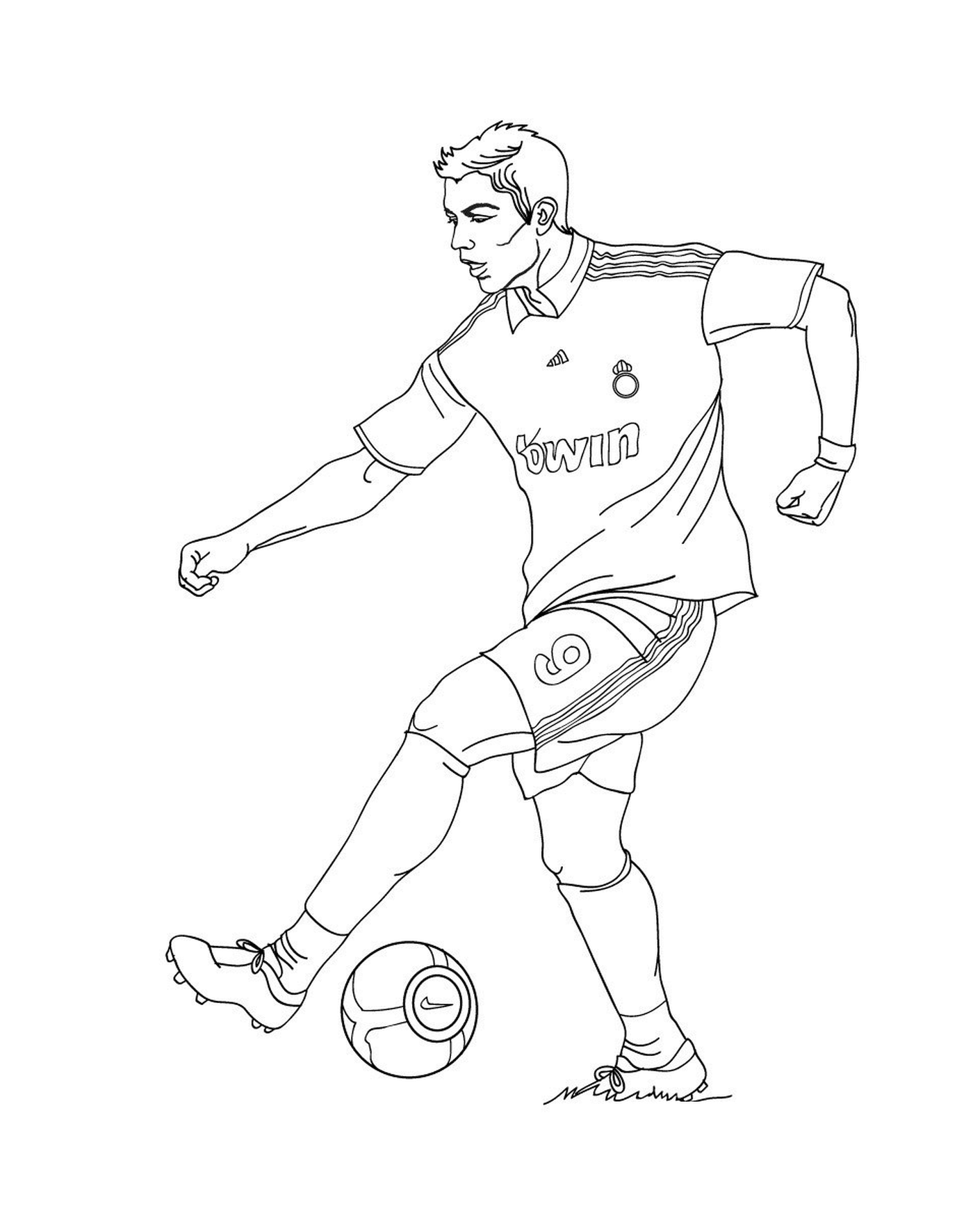   Un homme donnant un coup de pied dans un ballon de football sur un terrain 